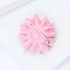 Détail du dos de la broche marguerite rose montrant l'attache en acier inoxydable