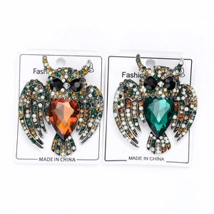 Detail of owl brooches with heart-shaped crystals and colorful rhinestones