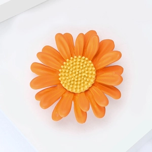 Vue macro de dessus d'une broche marguerite orange avec détails de pétales mats