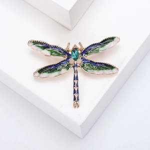Exquisite Libellen-Brosche mit Emaille und Smaragd-Edelstein auf weißem Hintergrund