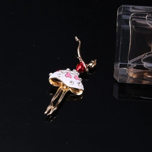 Détail d'une broche danseuse de ballet dorée avec émail rouge et strass brillants