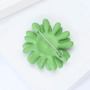 Vue détaillée du dos de la broche marguerite vert clair avec épingle de sûreté en argent