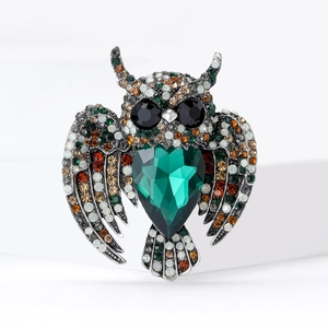 Vintage owl brooch with colorful rhinestones and a large heart-shaped emerald green gemstone