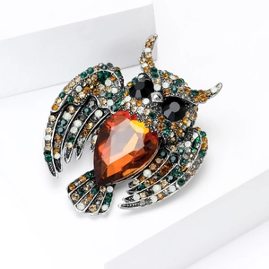 Detailed close-up of a vintage owl brooch featuring colorful rhinestones and amber stone