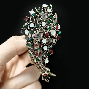 Detailed macro view of vintage gold flower bouquet brooch with multicolored rhinestones