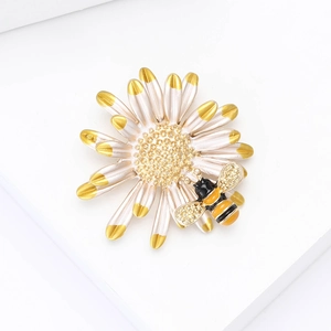 Detailed macro view of enamel daisy brooch with a golden bee and white petals