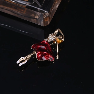 Detailaufnahme einer goldenen Ballettbrosche mit roter Emaille und funkelnden Strasssteinen