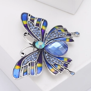 Macro di una spilla a farfalla in smalto con cristalli blu e finitura in stile vintage