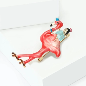 Detalle de un broche de flamenco en esmalte rosa con figura en miniatura sobre aleación dorada