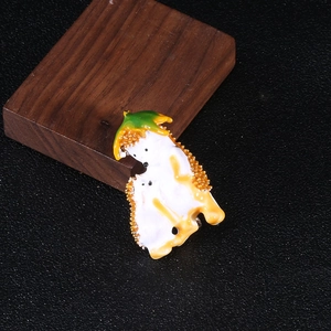 Close-up of cute hedgehog enamel brooch with detailed orange beads and leafy design