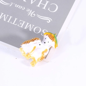 Detailed view of the enamel hedgehog brooch with intricate gold plating and vibrant glaze