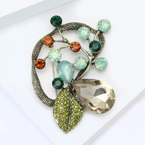 Detail of vintage bronze brooch with teardrop smoky stone and colorful crystal leaves