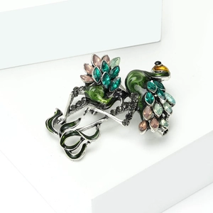 Macro detail of a vintage peacock brooch with colorful rhinestones on a white pedestal