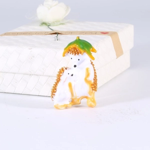 Detailed view of enamel hedgehog brooch with green leaf hat and golden beaded edge