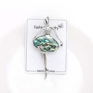 Detailed macro of a ballerina brooch with abalone shell skirt and sparkling rhinestones