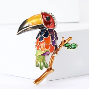Broche toucan exquise en émail avec strass colorés sur une branche dorée élégante