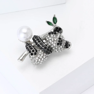 Sparkling silver koala brooch featuring black and white crystals with a large white pearl