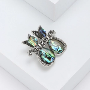Vintage retro cat brooch featuring natural abalone shell and rhinestones on a silver base
