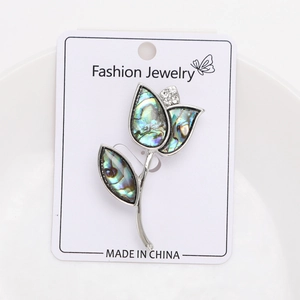 Macro view of vintage tulip flower brooch featuring iridescent abalone shell petals