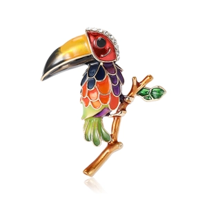 Broche toucan colorée en émail avec des strass étincelants sur une branche polie