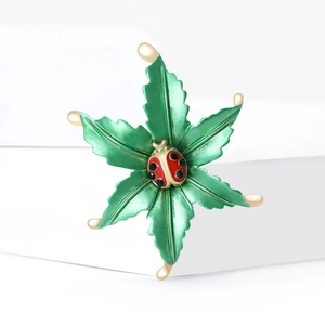 Elegant alloy enamel ladybug on green leaf brooch with gold accents and metallic finish