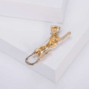 Back view of a gold-tone leopard brooch showing the pin mechanism on a white base