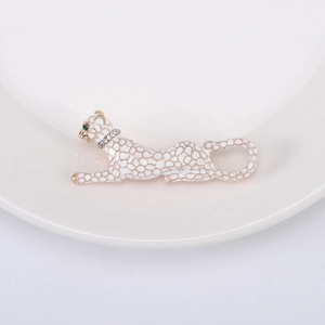 Macro detail of leopard brooch with white enamel, gold grid pattern and green gem eyes