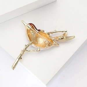 Detailed close-up showing the secure pin clasp on the back of the golden bird brooch