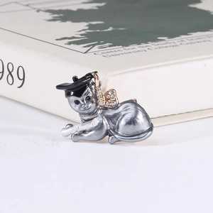 Macro detail of cartoon cat graduation brooch with crystal bow and diploma scroll