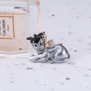 Detailed close-up of a graduate cat brooch with rhinestone bow and gold tassel details