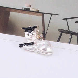 Detail of cartoon graduation cat brooch with pearl enamel and sparkling rhinestones