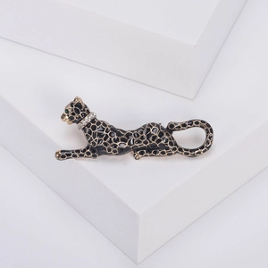 Detail of elegant black enamel leopard brooch with green eyes and sparkling crystal collar