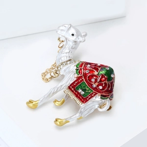 Detailed macro view of exotic camel brooch featuring white enamel and sparkling crystals