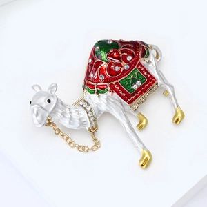 Close-up of a camel brooch with white enamel details and sparkling rhinestone accents