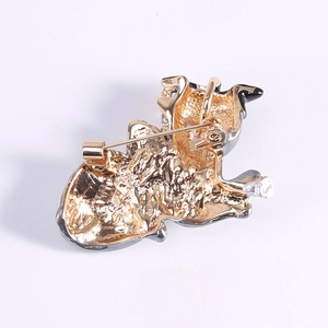 Golden cartoon puppy brooch back view showing metal texture and pin closure mechanism