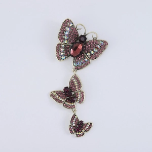 Macro shot of three vintage butterfly brooches with pink crystals and ruby stones