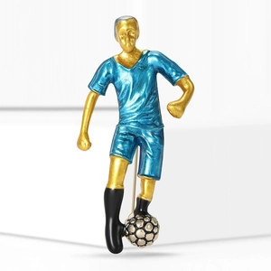 Creative soccer player brooch in blue jersey with golden details on a white pedestal