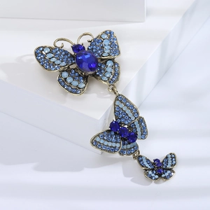 Macro detail of vintage bronze butterfly brooch with blue rhinestones and gems