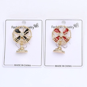 Detail view of black and red electric fan brooches with sparkling rhinestone accents