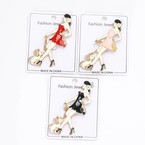 Three elegant enamel lady brooches with cats and high heels on card packaging