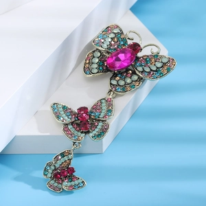 Macro detail of vintage alloy butterfly brooch with colorful rhinestones and pink gemstone