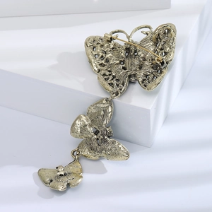 Detailed back view of vintage gold alloy butterfly brooch with pin clasp and relief texture