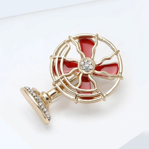 Macro detail of retro fan brooch with red enamel blades and sparkling crystals on alloy