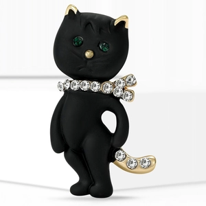 Elegante schwarze matte Katzenbrosche mit grünen Edelsteinaugen und Kristallschleife
