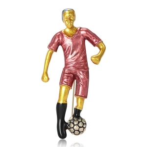 Creative soccer player brooch in gold metal and red enamel with ball detail