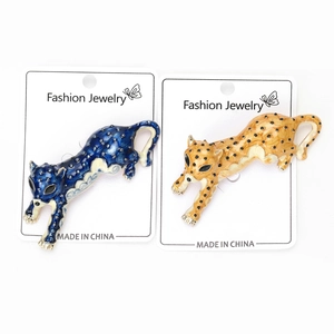 Detail of leopard brooches featuring blue and yellow enamel with black spots on card