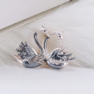 Vue détaillée d'une broche double cygne avec émail gris et strass brillants sur fourrure