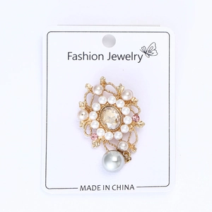Vue détaillée d'une broche florale vintage avec strass roses et perle grise pendante