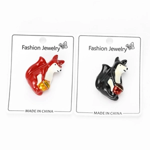 Détail de broches de renard en émail rouge et noir sur des cartes de présentation bijoux