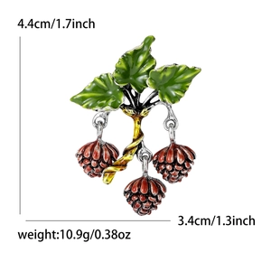 Creative enamel hazelnut brooch with green leaves and gold branches on white background
